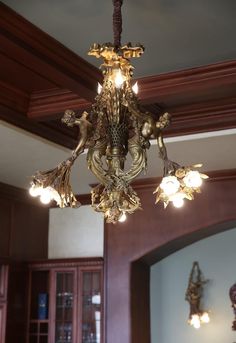 a chandelier hanging from the ceiling in a room with wood trimmings