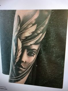 a woman's face with feathers on her arm