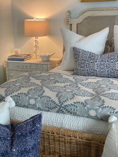 a bed with blue and white pillows on it