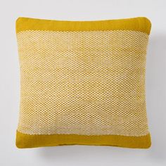 a yellow and white pillow sitting on top of a wall