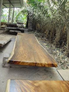 several wooden benches lined up next to each other in front of some trees and bushes