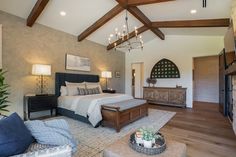 a bedroom with a large bed and wooden beams on the ceiling is decorated in neutral colors