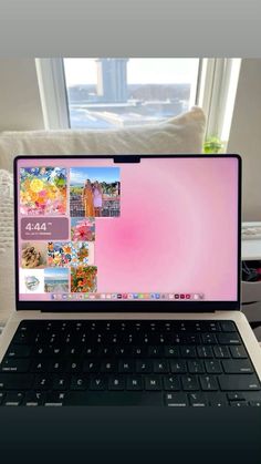 an open laptop computer sitting on top of a white table in front of a window