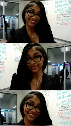 a woman wearing glasses and smiling in front of a whiteboard with writing on it