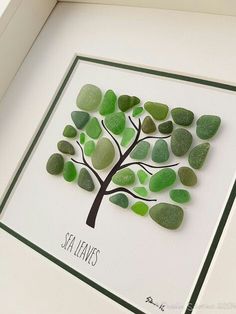 a card made with sea glass and a tree on the front, surrounded by green leaves