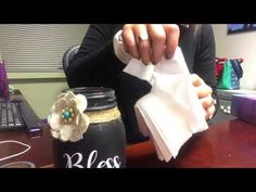 a person sitting at a desk with some napkins in front of them and a jar on the table