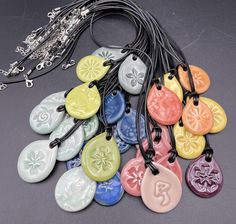 a bunch of different colored tags on a black cord and some type of necklace with charms attached to it