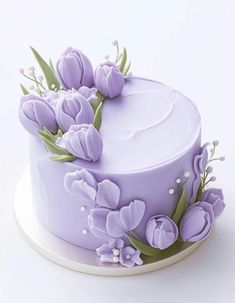 a cake decorated with purple flowers and greenery