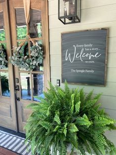 a potted plant sitting in front of a door with a welcome sign above it