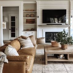 a living room filled with furniture and a flat screen tv mounted on the wall above a fire place