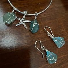 three pieces of jewelry sitting on top of a wooden table