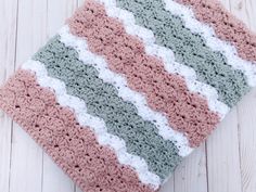 a crocheted dishcloth is laying on a white surface with wood flooring