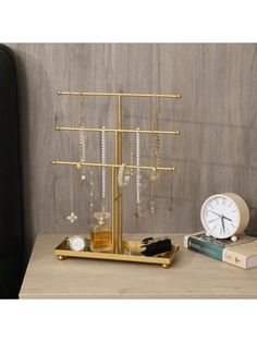 a clock and some necklaces are on a table next to a shelf with books