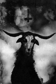 a black and white photo of a goat with horns on it's head in front of a cross