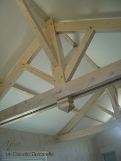 an unfinished ceiling with wooden beams in a room