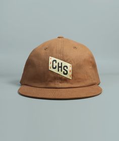 Our CHS Embroidered Charleston hat features hand embroidered and woven patch details, a perfectly worn in feel, front and back woven patch details, and adjustable brass buckle clasp.Made from washed 100% cotton twill fabricFabric strap with adjustable brass buckle claspDue to the handmade nature of this design items may have slight variations Pre-washed Cotton 5-panel Hat, Brown Snapback Hat With Embroidered Logo And Flat Brim, Brown Flat Brim Snapback Hat With Embroidered Logo, Brown Hat With Logo Patch For Streetwear, Brown Streetwear Hats With Logo Patch, Adjustable Canvas Hat With Embroidered Logo, Retro Adjustable Cotton Dad Hat, Vintage Adjustable Canvas Baseball Cap, Adjustable Brown Baseball Cap With Letter Patch