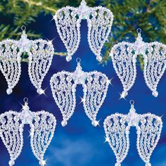 six ornaments hanging from a christmas tree on a blue background with snowflakes and stars