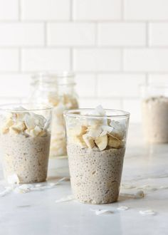 three glasses filled with oatmeal sitting on top of a white countertop