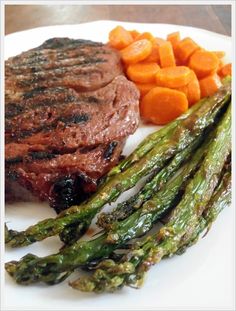 steak, asparagus and carrots on a white plate