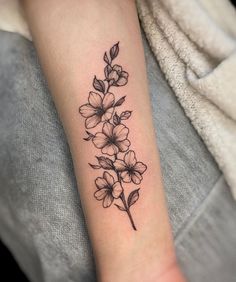 a black and white flower tattoo on the arm