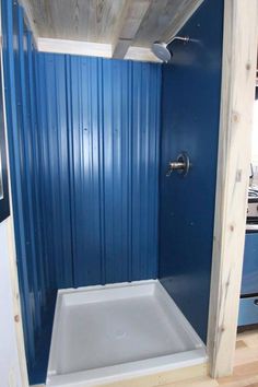 a bathroom with blue walls and a white bathtub next to a stove top oven