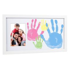 two children's handprints are displayed in a white frame with an image of them