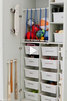 a white closet filled with lots of bins and baskets next to a baseball bat