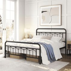 a bedroom with white walls and flooring has a metal bed frame in the middle