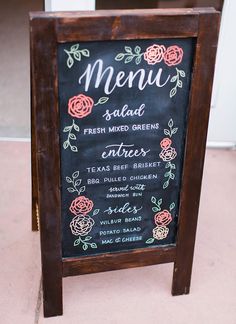 a chalkboard menu sign with roses on it