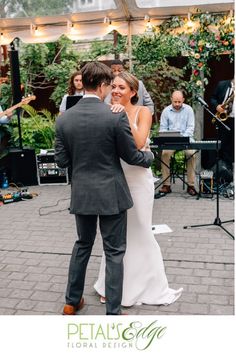 a bride and groom sharing their first dance at the wedding reception in front of an outdoor band