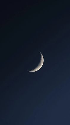 the crescent moon is seen against a dark blue sky