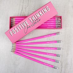 pink pencils with writing on them sitting in a pink box next to each other