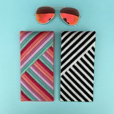 two pairs of sunglasses sitting next to each other on top of a blue surface,