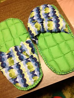 two green and blue slippers sitting on top of a table