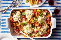 two plates of pasta with cheese and tomato sauce on a blue and white tablecloth