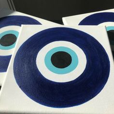 three blue and white circles painted on canvases