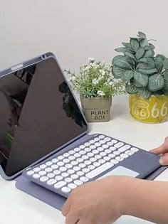 a person is typing on the keyboard of an open laptop