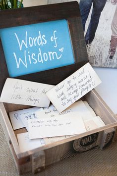 a wooden box filled with lots of writing on top of a white table next to a blue sign