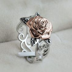 a rose ring sitting on top of a white blanket