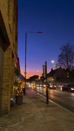 a city street at night with cars driving on it