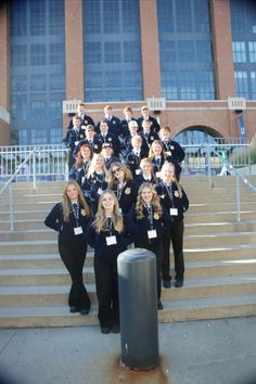 a group of young women standing next to each other in front of a large building