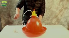 a person standing next to a table with an orange object on it