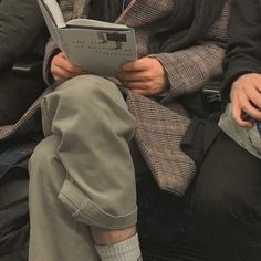 two people sitting next to each other reading books