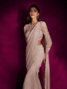 Dusty pink georgette fish style sari heavily hand embellished with pearls, silver glass beads, mixed materials & tassels, paired with a champagne and silver floral embellished sheer blouse featuring an open back.From Shloka Khialani's Winter Sun collection.DELIVERY TIMEPlease allow 6-8 weeks for your outfit to arrive.FABRIC DETAILSGeorgette, NetProfessional cleaning only. Sari Wedding Guest, Winter Wedding Guest Outfit Indian, Full Sleeve Blouse, Bridesmaid Saree, Wedding Saree Collection, Net Blouses, Fancy Sarees Party Wear, Modern Saree, Saree Designs Party Wear