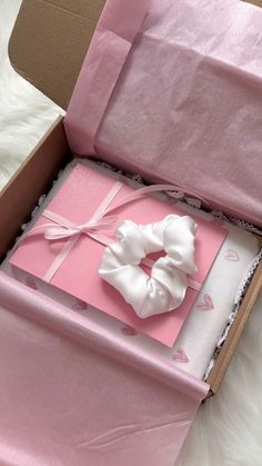 an open pink box with a white bow on it