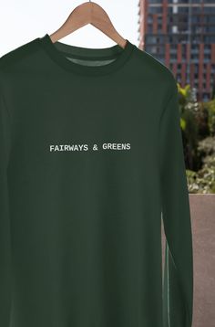 This minimalist designed golf sweatshirt is perfect for any golfer looking to hit fairways and greens in style. The simple design features a lightweight cotton-blend fabric and a golf graphic on the front. The crewneck design is comfortable, breathable and has a fit that's easy to move in, giving you the freedom to focus on your game. Whether you're on the green or just wanting to show your love for golf, this sweatshirt is a great way to let everyone know you mean business. Information - Gildan Golf Shirt Outfit Women, Golf Team Shirts High School, Green Crew Neck Top For Golf, Golf Tee, Golf Tshirt, Golf Shirt, Golf Tee Shirt Design, Sporty Crew Neck Sweatshirt For Golf, Golf Sweatshirt