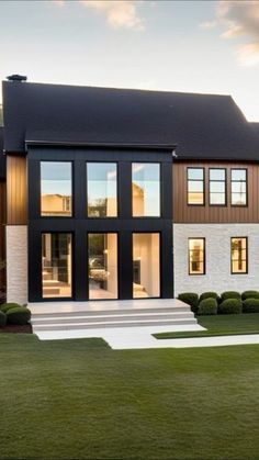 a modern house with large windows and grass