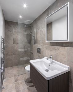 a bathroom with a sink, mirror and shower stall