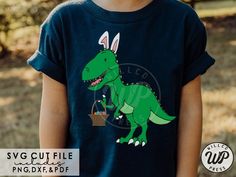 a young boy wearing a t - shirt with an image of a dinosaur on it