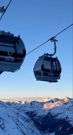 two ski lifts are above the snow covered mountains